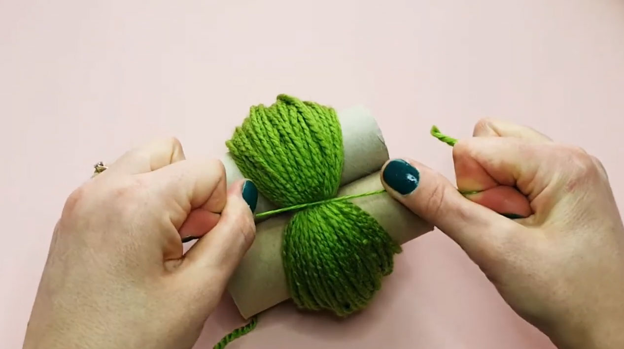 A picture of the step of making pom poms using toilet paper rolls.