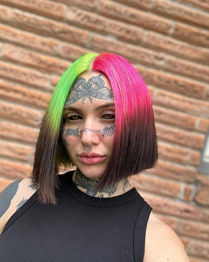 Woman with colorful hair and facial tattoos, showcasing inked look. Woman with colorful hair and facial tattoos, showcasing inked look.
