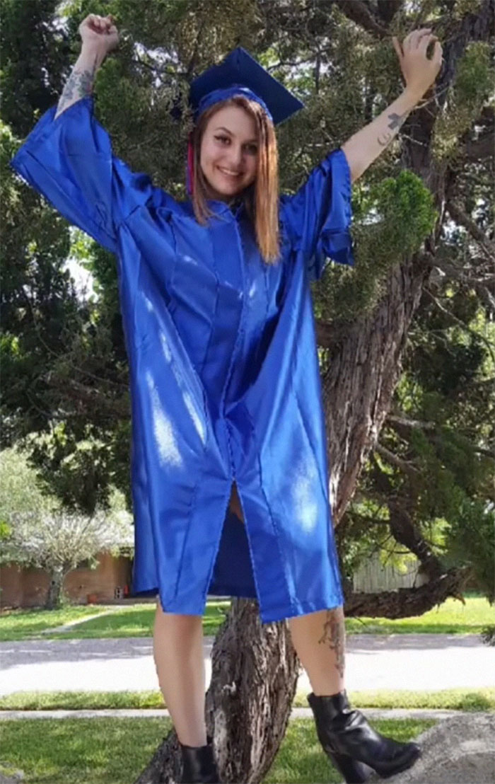 Woman celebrating in blue graduation robe, showing inked body modifications. Woman celebrating in blue graduation robe, showing inked body modifications.