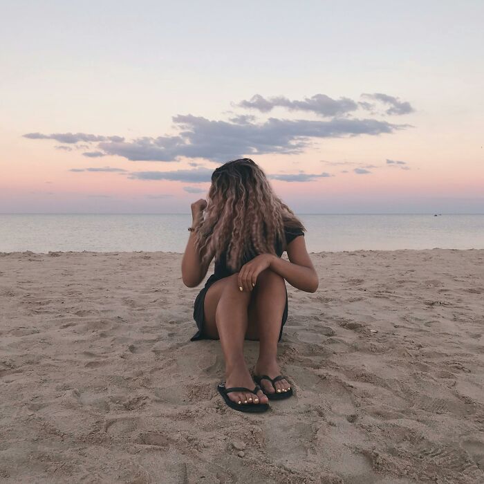 Girl sitting on the beach with flip-flops 