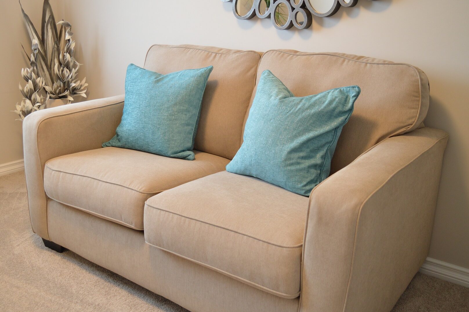 picture of a small brown couch with blue pillows