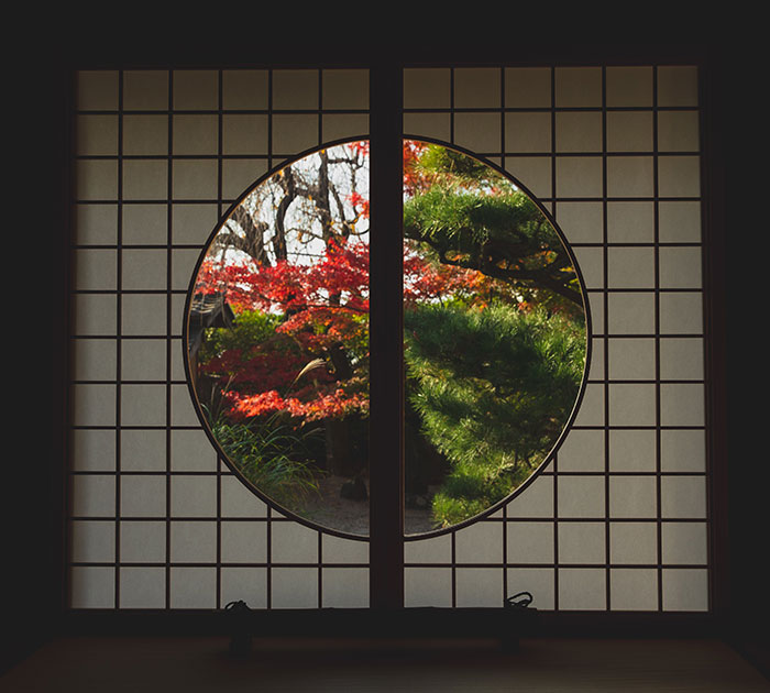 Window in Japanese style with view of trees in autumn
