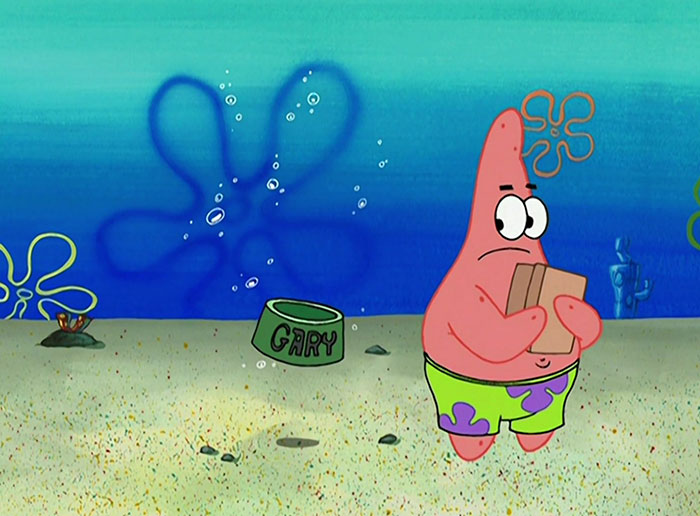 Patrick looking behind him and holding a box 