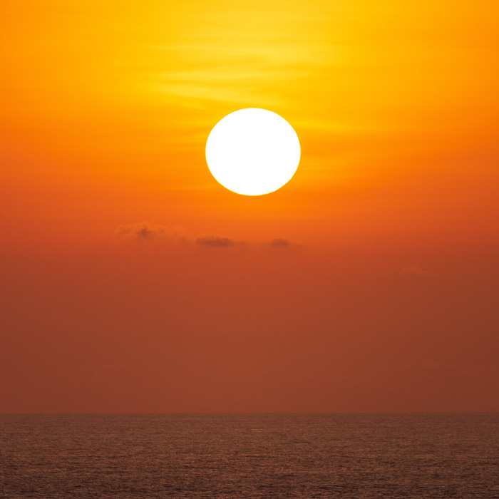 Sun rising above the ocean 