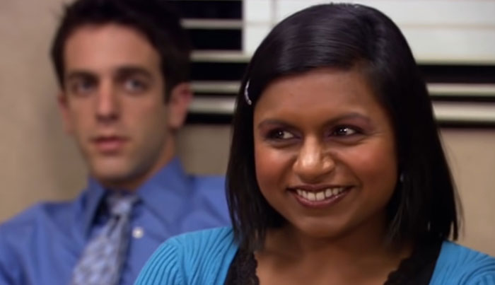 Kelly Kapoor smiling and looking at someone 