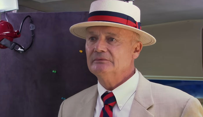 Creed Bratton standing with his hat on 