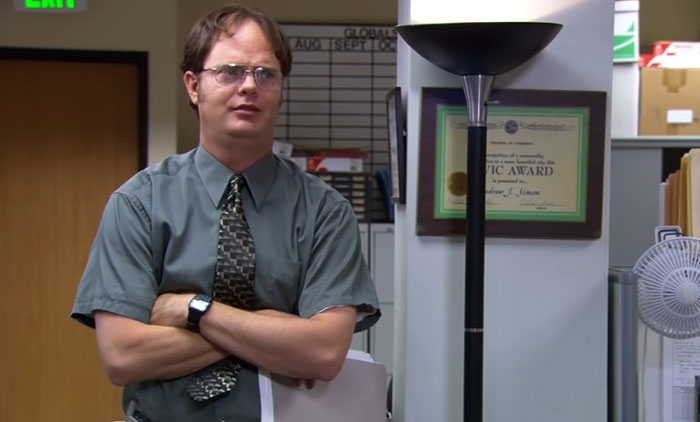 Dwight Schrute talking with his hands crossed 