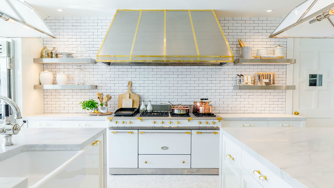 Image of a kitchen with white cabinets and gold accents.