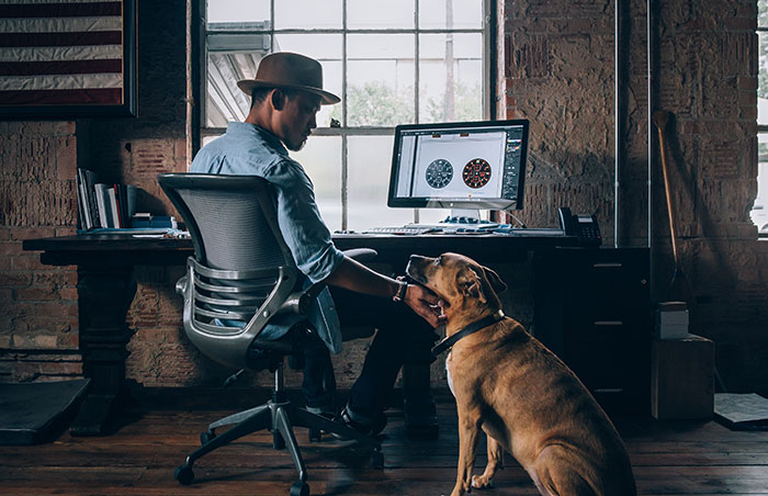 Man sitting near computer and petting dog. Man sitting near computer and petting dog.
