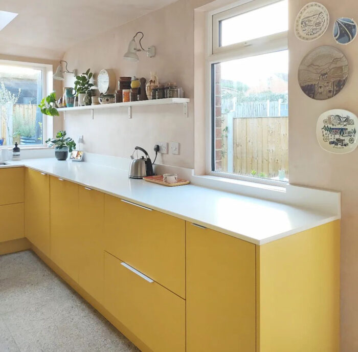 Bright lemon yellow base cabinets with the kettle on it