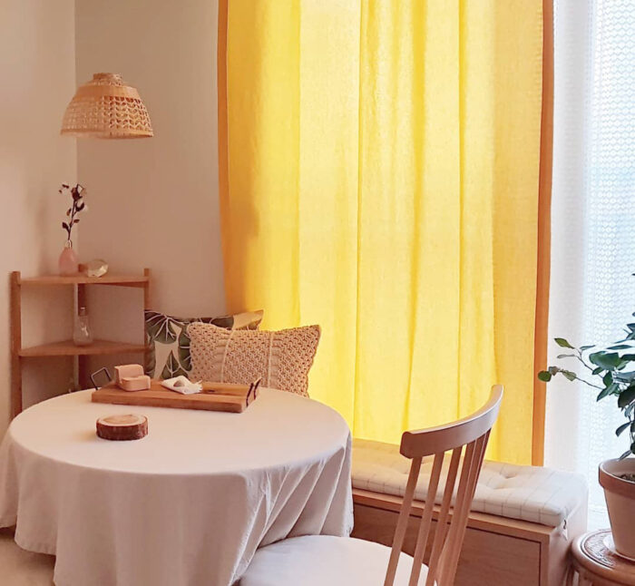 Dining table with chair and bench on the background of a yellow curtain