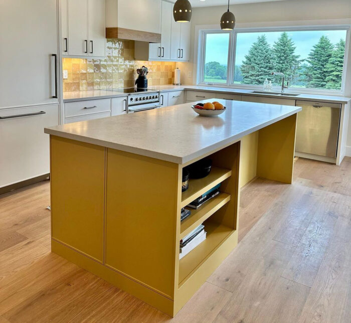 A yellow kitchen island with a plate of fruits