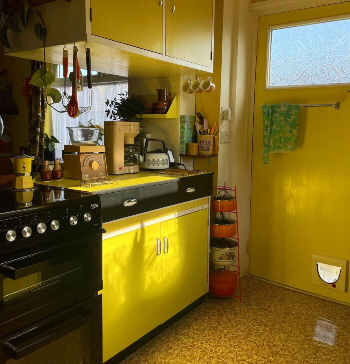 A lot of kitchenware on a yellow and black cabinet