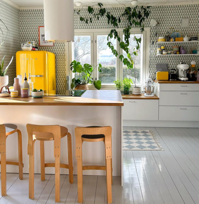 Wooden island in the kitchen on the background of a yellow fridge