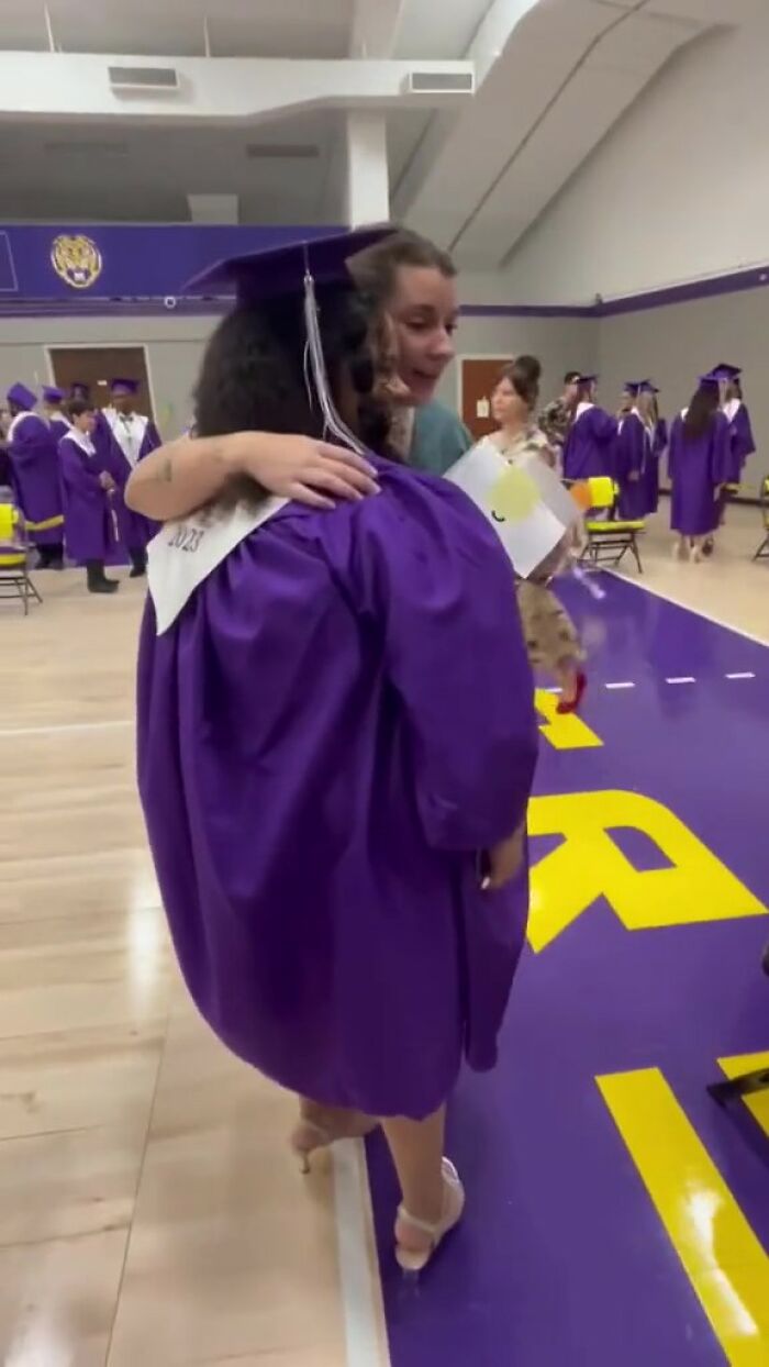 Graduating student in a purple gown receives a heartfelt hug, emphasizing meaningful teacher connections. Graduating student in a purple gown receives a heartfelt hug, emphasizing meaningful teacher connections.