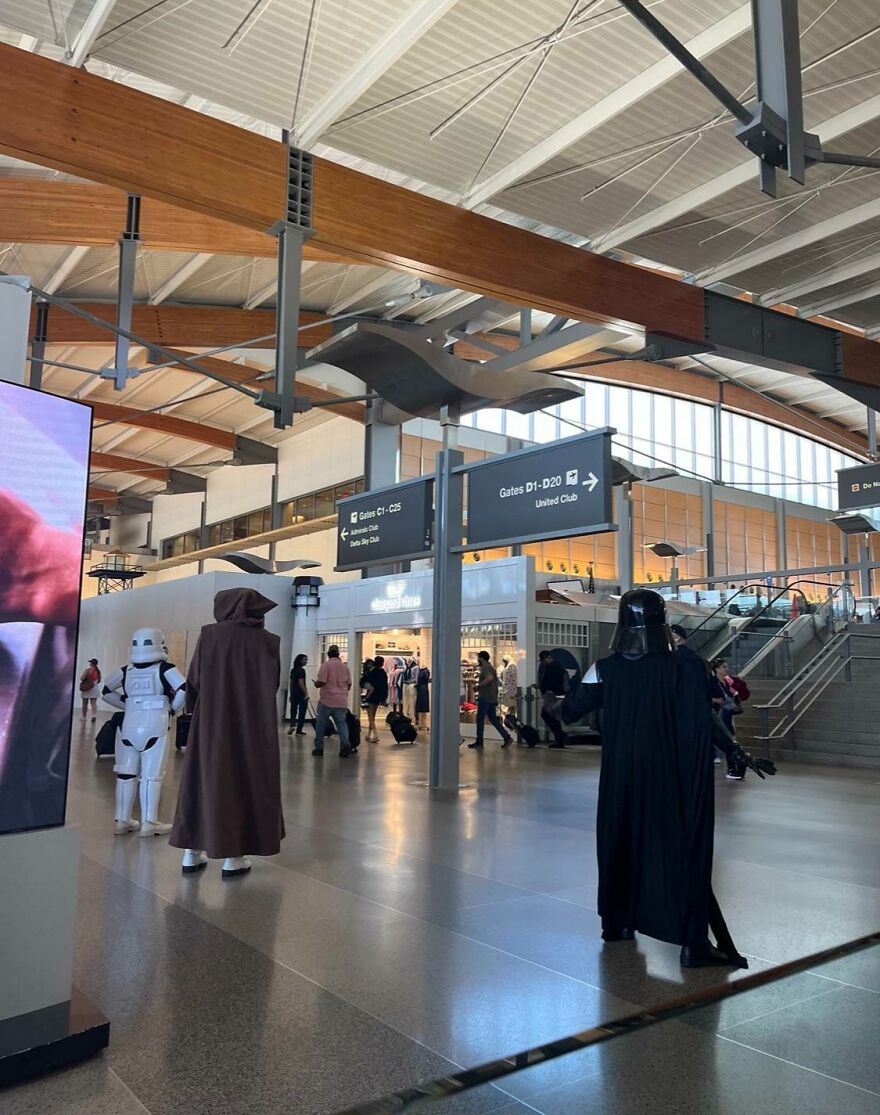 Multiple Star Wars characters in an airport 