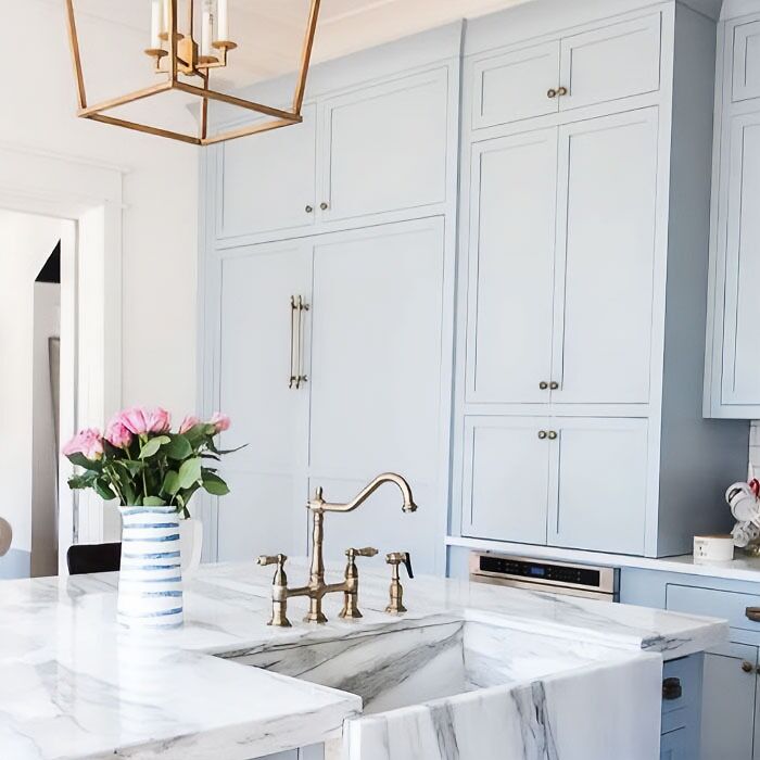 Light blue kitchen cabinets near marble table