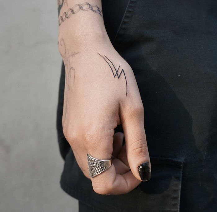 Black minimal abstract tattoo on hand