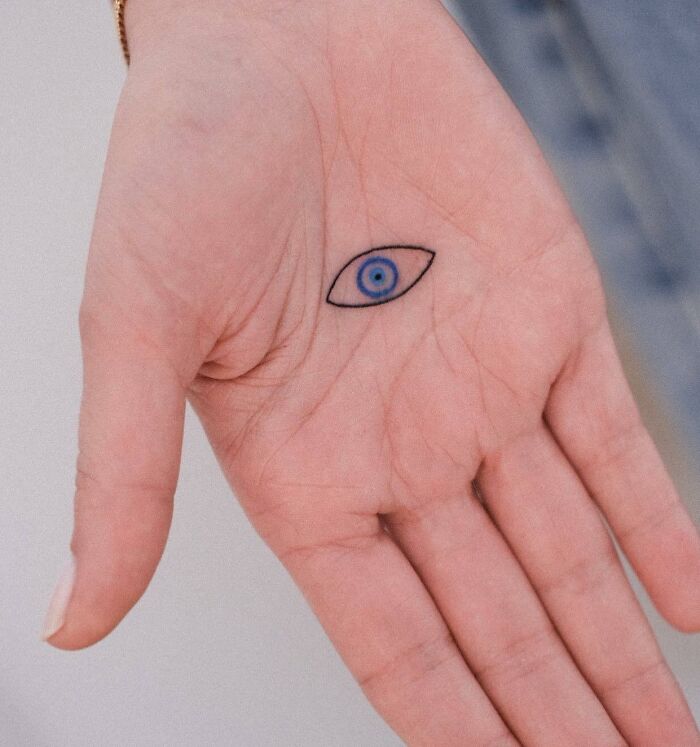Small blue eye tattoo on palm