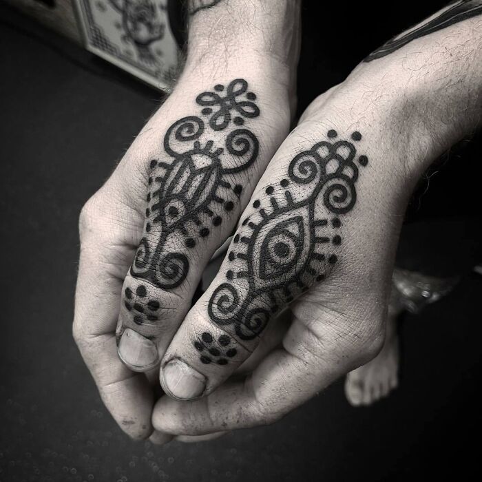 Black ornamental thumb tattoo