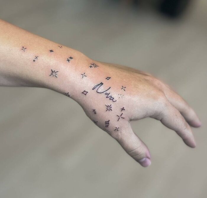 Mini stars and lettering ‘Nova’ tattoos on hand