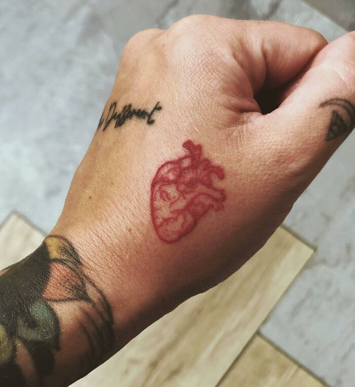 Red heart tattoo on hand