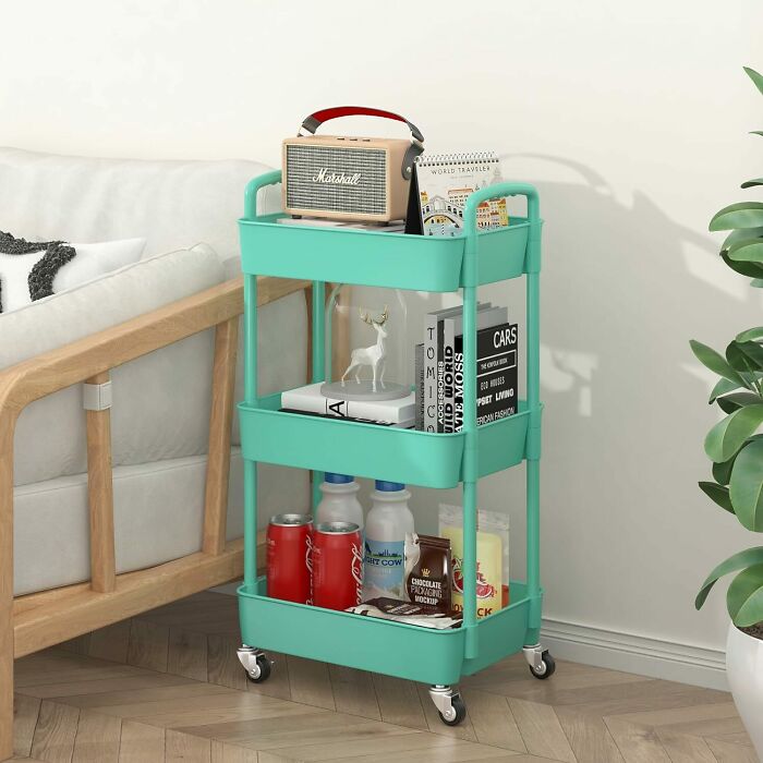 Mint green 3-tier plastic rolling utility cart with handle and things in it