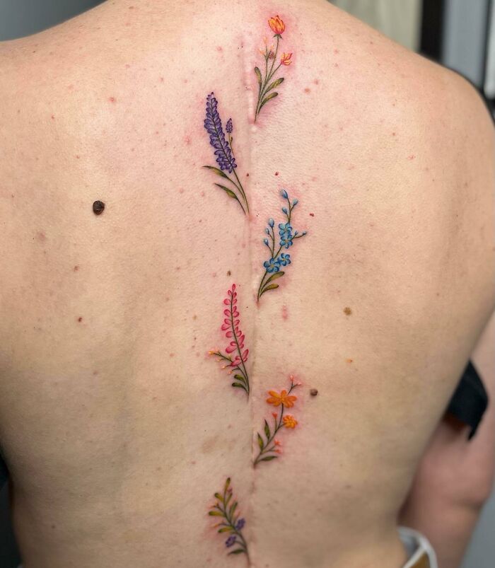 Many colorful flowers spine tattoo