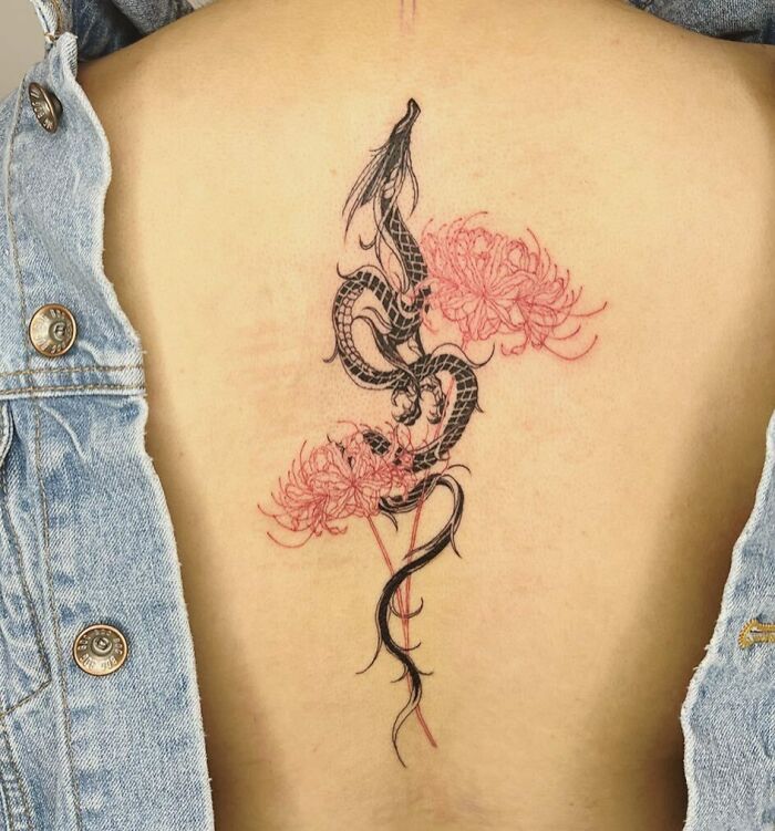 Black dragon and two red flowers spine tattoo on back