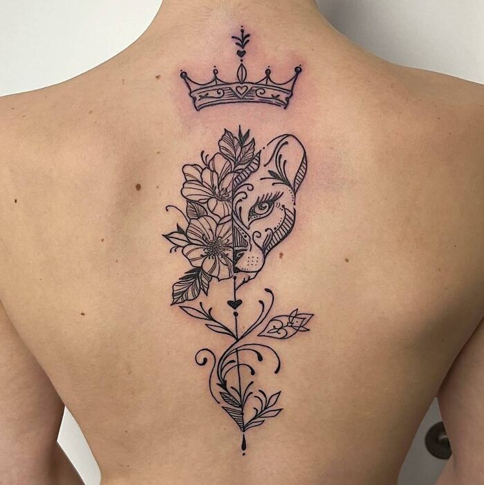 Abstract floral and lion spine tattoo design with a crown at the top.