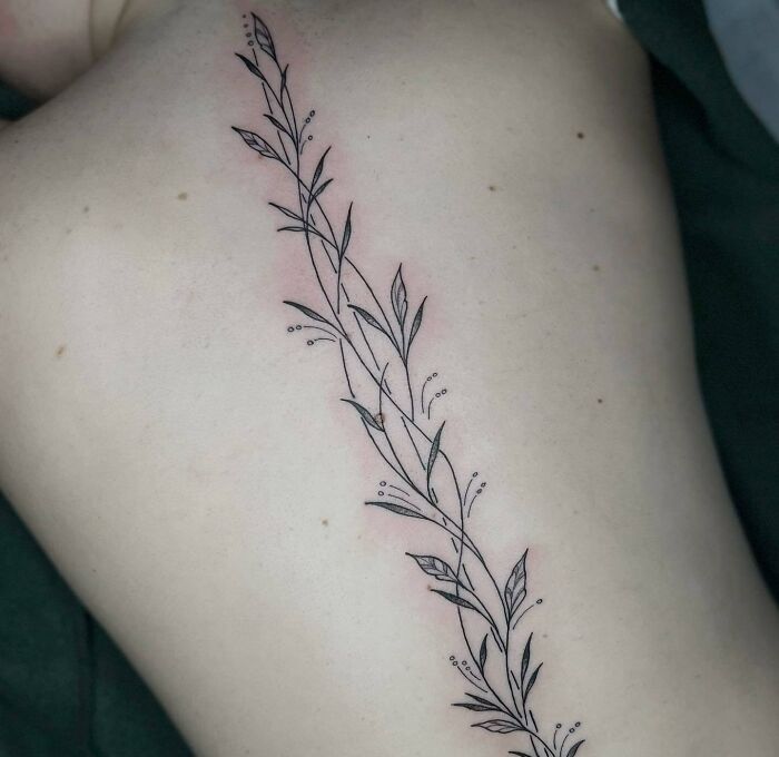 Floral linear spine tattoo