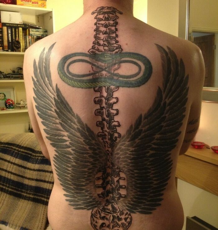 Spine and wings tattoo on back