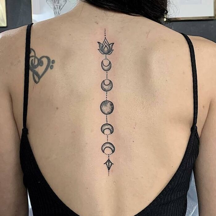 Moon phases and lotus tattoo on spine
