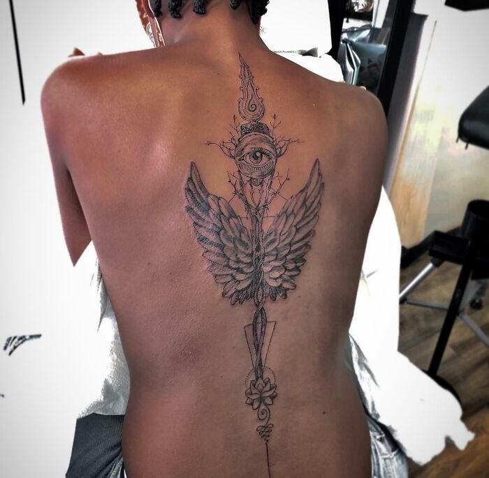 Large spine tattoo design with wings and eye