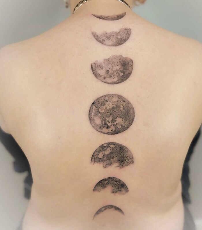 Large realistic moon phases spine tattoo