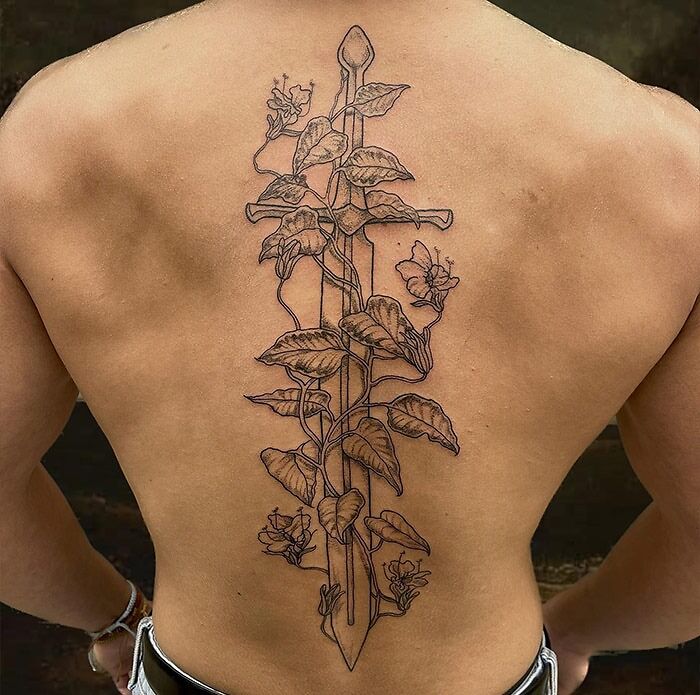 Intricate vine and sword spine tattoo design, showcasing detailed leaves and flowers.