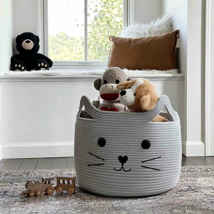 Large gray woven cotton rope storage basket with a cat face and plush toys in it