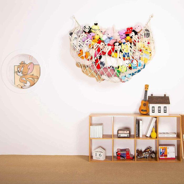 Hanging hammock storage on the wall with stuffed animal toys in it