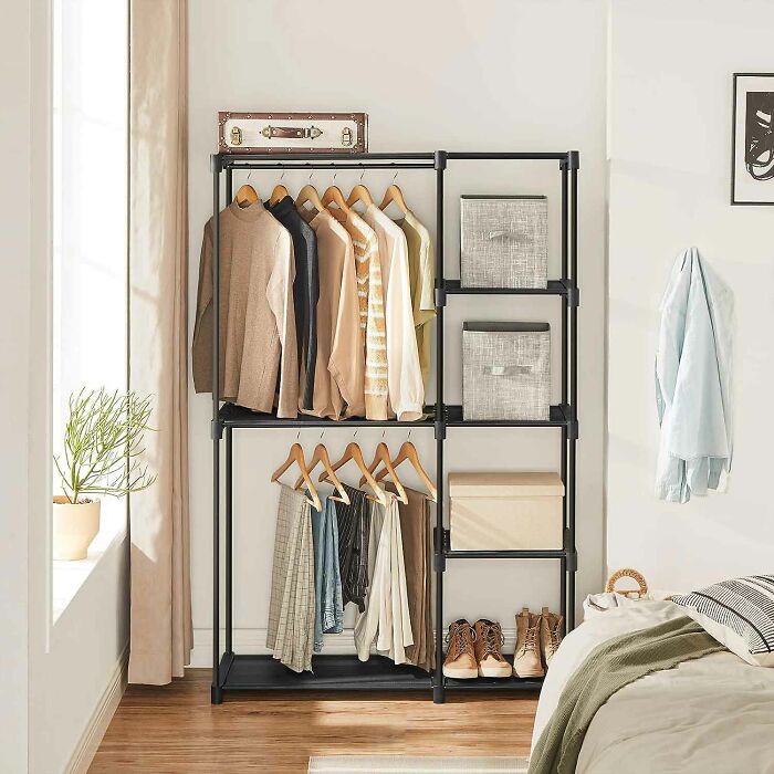 Black portable closet with shelves and clothes neatly hung