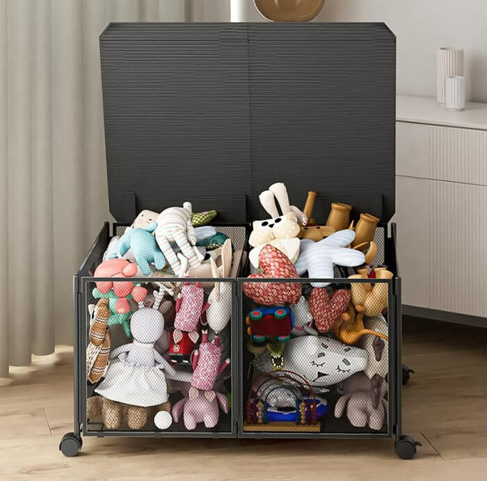 Black toy box storage with wheels, open lid, and many toys in it