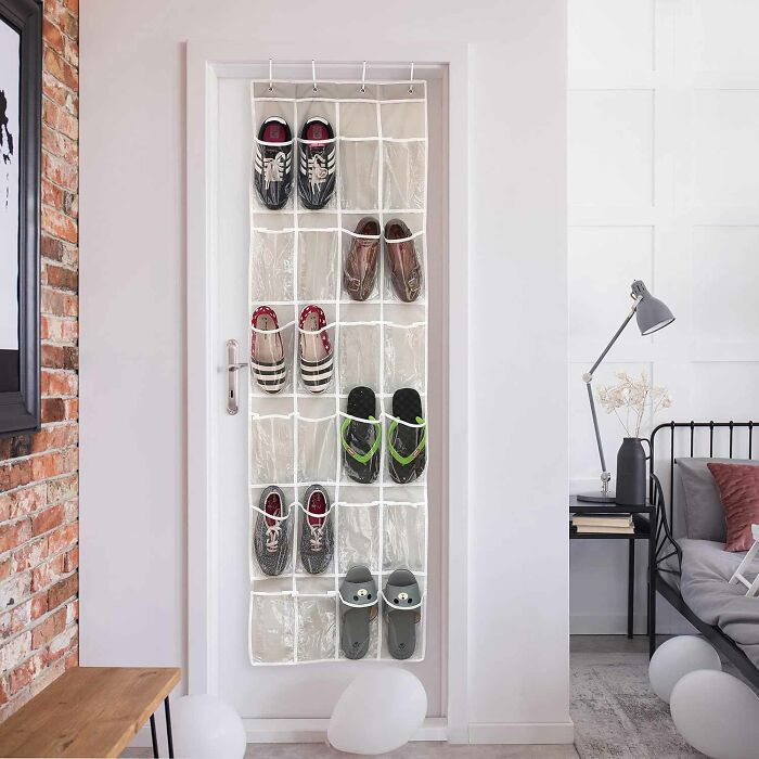 Clear over-the-door hanging shoe organizer with 24 pockets and shoes in some pockets