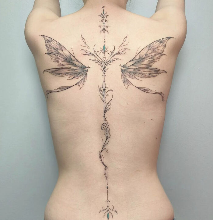 Large butterfly wings elfish spine tattoo