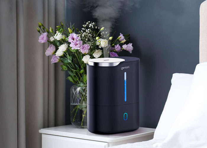 Black humidifier near the vase with flowers