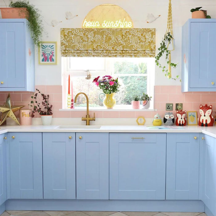 Light blue kitchen cabinets near window