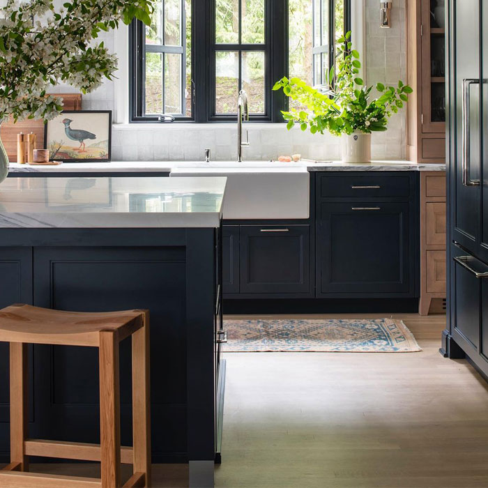 Dark blue kitchen cabinets with dark blue table with marble countertop