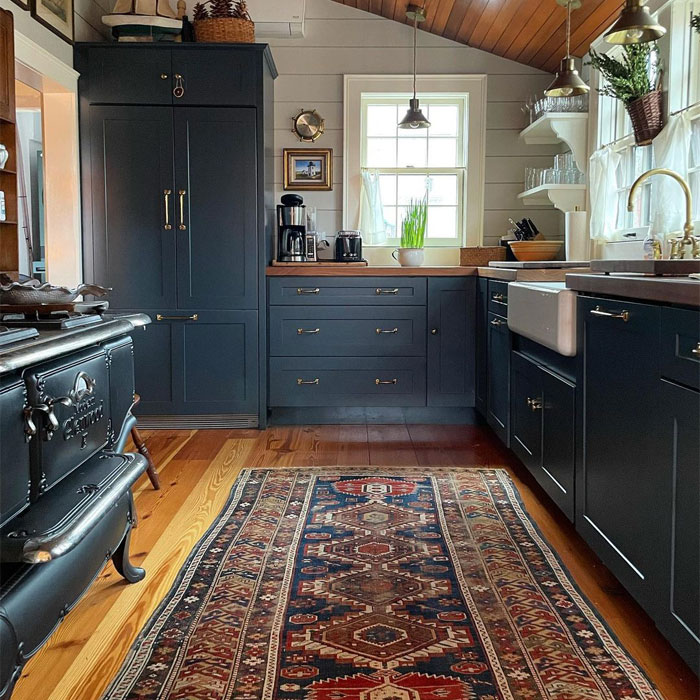 Dark blue kitchen cabinets near windows