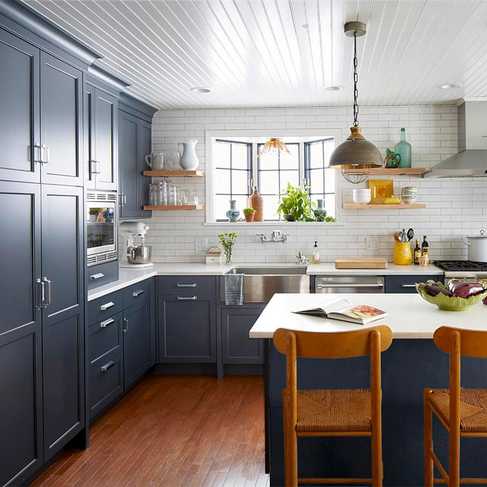 Dark blue kitchen cabinets with white tile wall