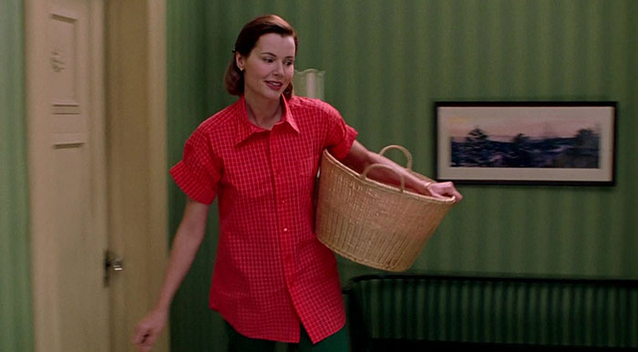 Geena Davis walking with a laundries basket 