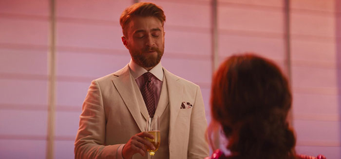 Daniel Radcliffe holding a glass of wine and talking 