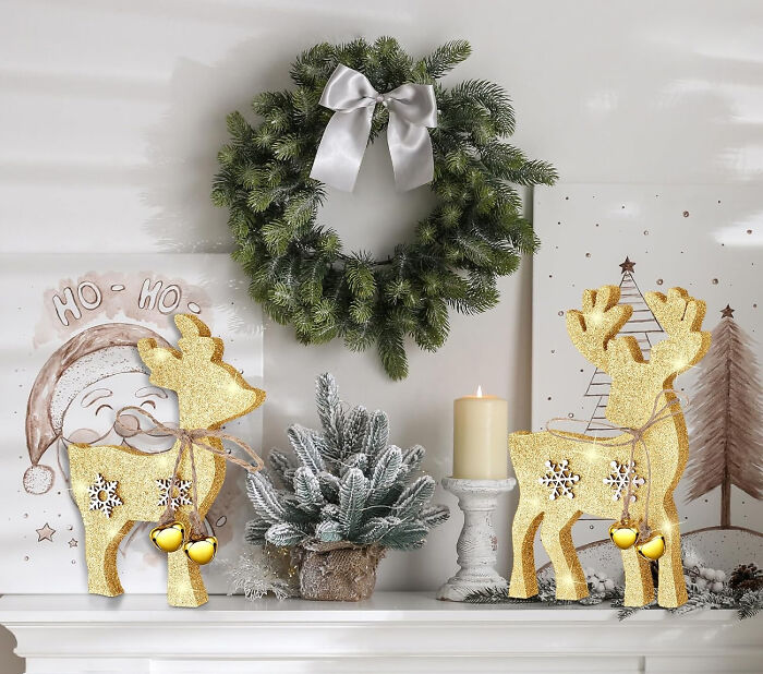 Wooden christmas deers near christmas tree and wreath